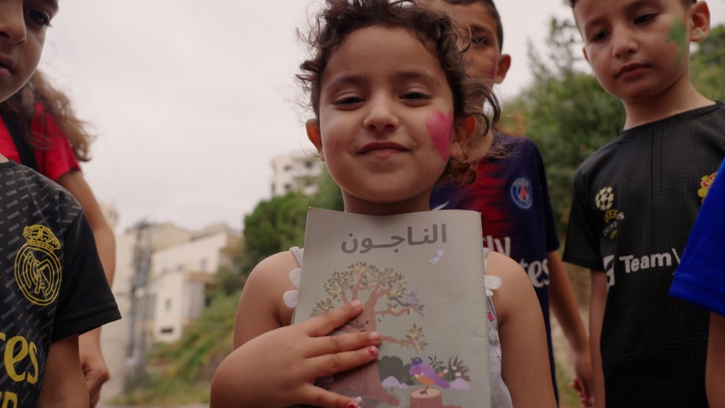 Lebanese child holding up Survivors program