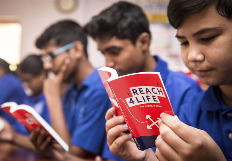 Young children reading Reach4Life Bibles